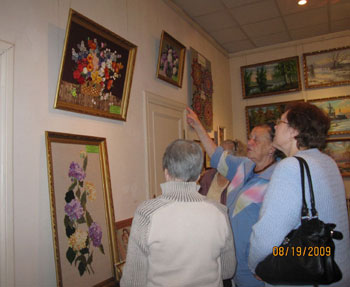 Посетители выставки рассматривают вышивки Светланы Бабушкиной.